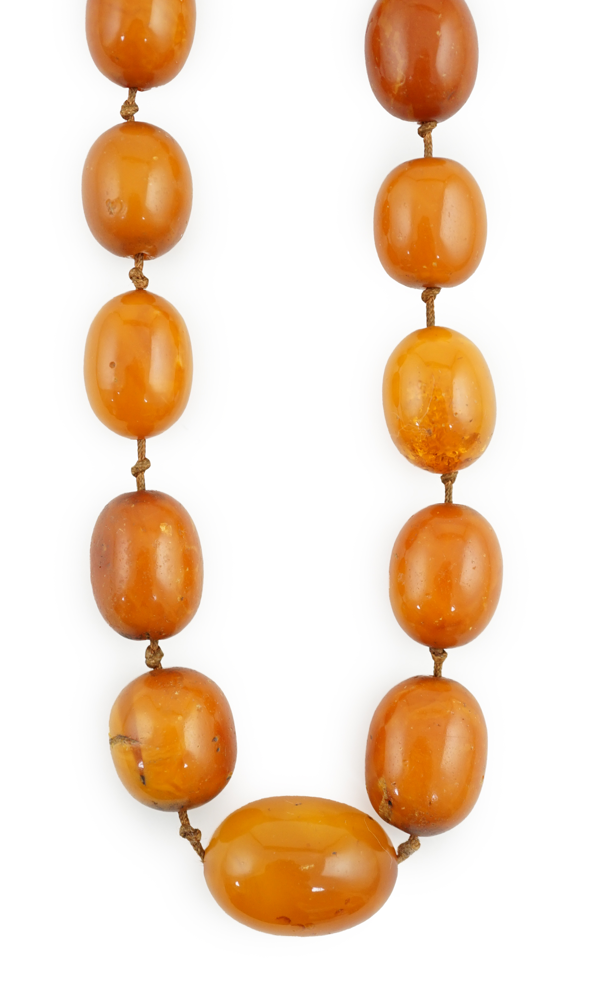 A long single strand graduated amber bead necklace